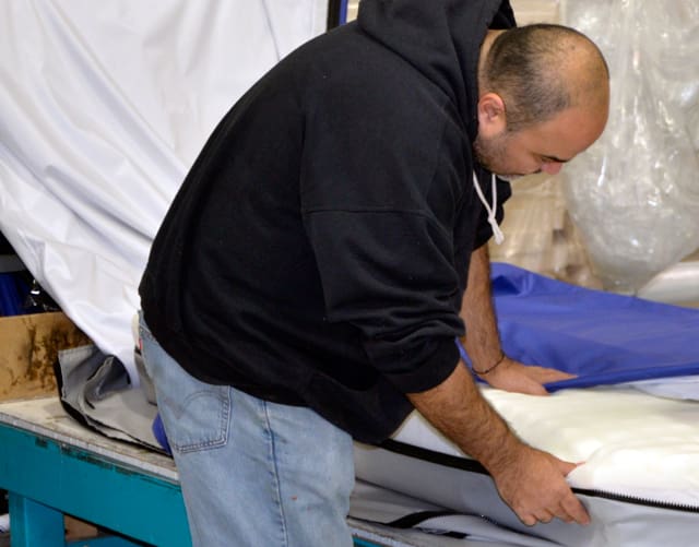 An Alpha Tekniko employee performs a final quality inspection before mattresses are packaged for shipping.